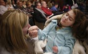 At a House of Representatives committee meeting to review a bill for medical marijuana, MaryAnn Nelson of Mankato kissed her daughter Rachel's hand. R