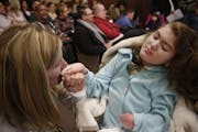 At a House of Representatives committee meeting to review a bill for medical marijuana, MaryAnn Nelson of Mankato kissed her daughter Rachel's hand. R