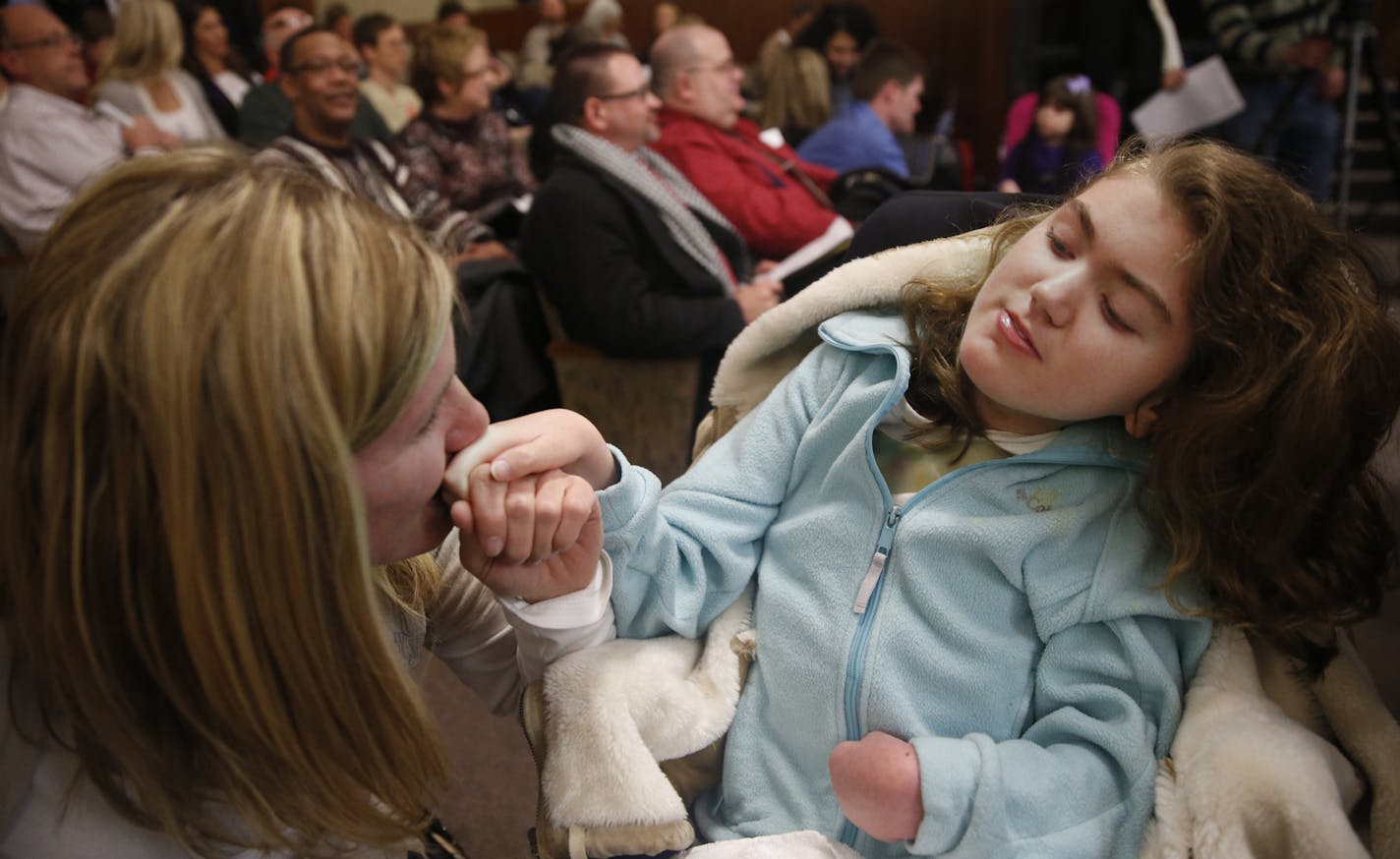 At a House of Representatives committee meeting to review a bill for medical marijuana, MaryAnn Nelson of Mankato kissed her daughter Rachel's hand. Rachel suffers from Rett Syndrome. "I don't want have to move to Colorado," she says stating that she has found research that medical marijuana can reduce seizures .]richard tsong-taatarii/rtsong-taatarii@startribune.com ORG XMIT: MIN1403041835141199