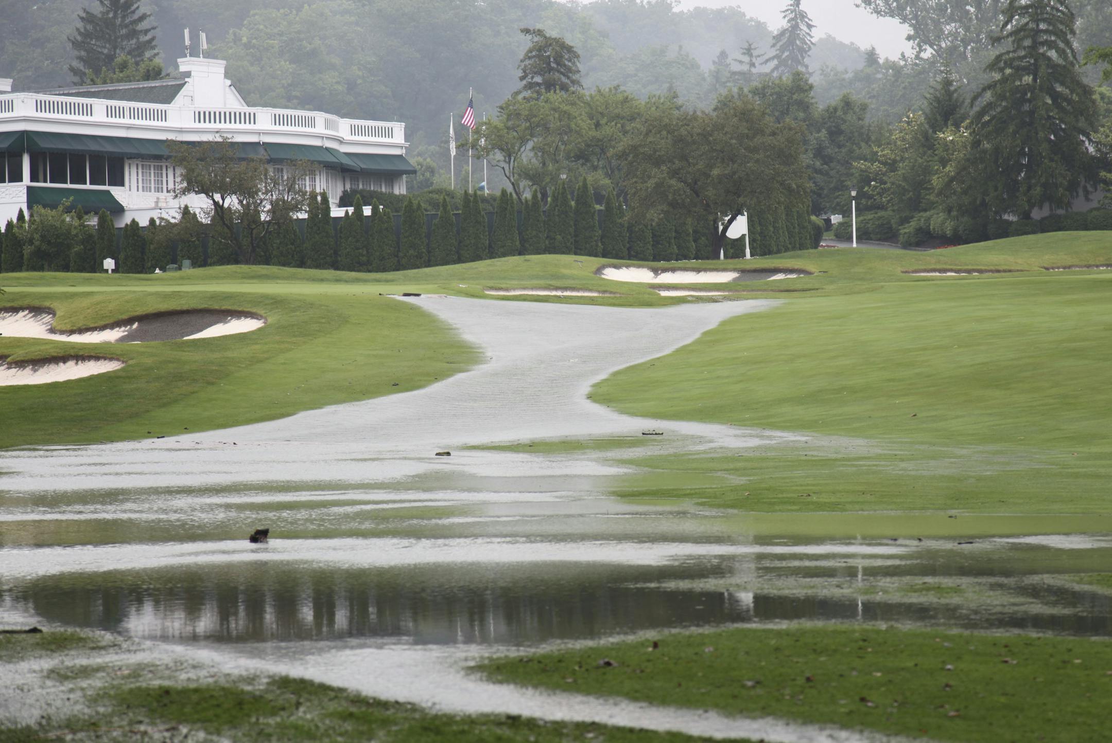 This Thursday June 23, 2016 image provided by the Greenbrier shows flooding on a fairway in front of the clubhouse of the Old White Course at the Greenbrier in White Sulphur Springs, W. Va. Severe flooding hit the area that is scheduled to host a PGA tour event in two weeks. (Harry Watson/The Greenbrier via AP)