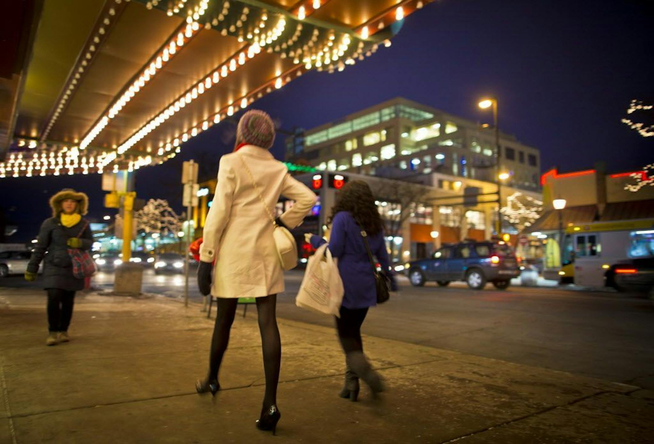 People walked under the Uptown theater marquee with a view of the 10 story MoZaic building in Uptown on Thursday, February 21, 2013, Minneapolis, Minn.
