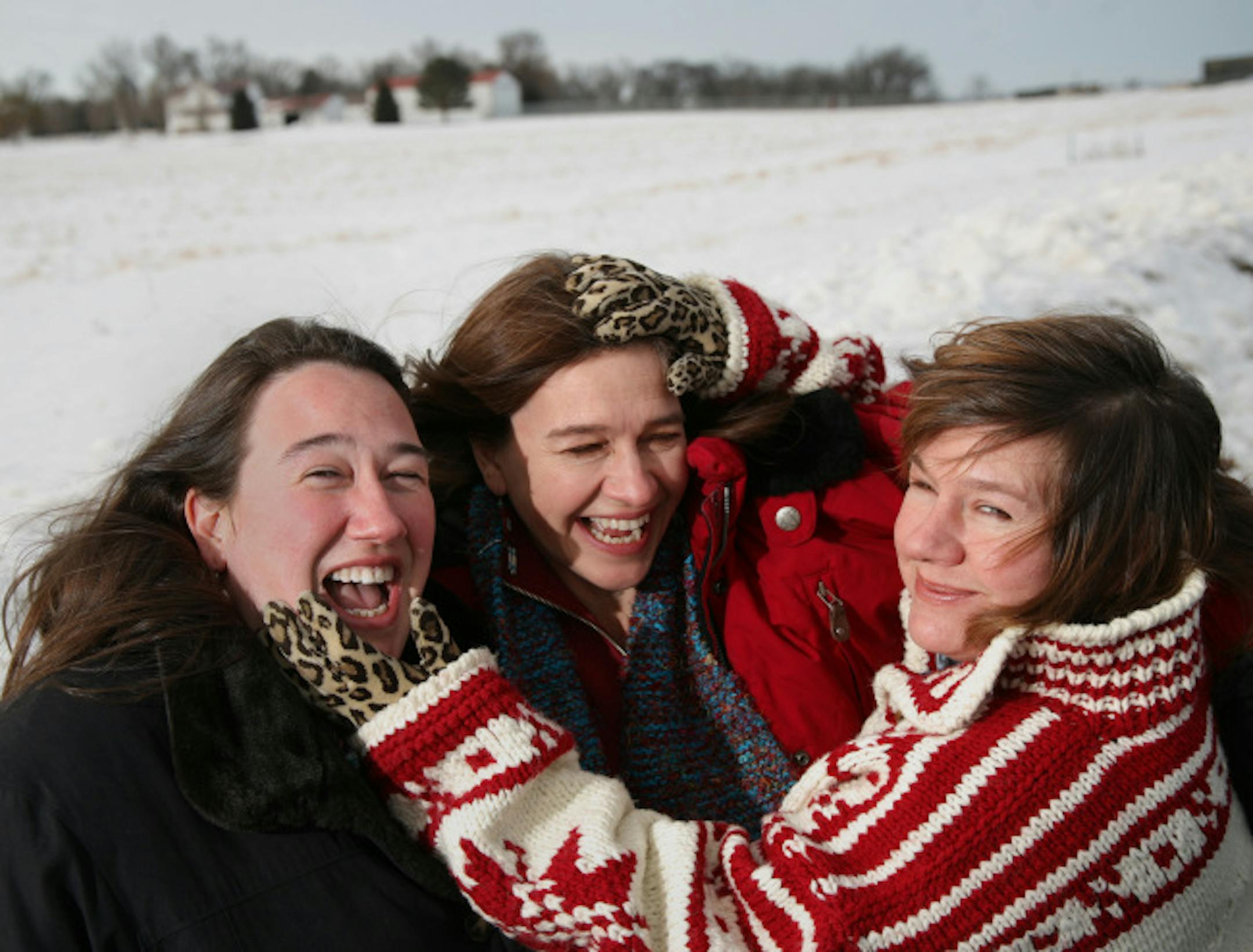 The three Erdrich sisters, from left, Heid, Louise and Lise enjoy a moment together during a photo shoot out on the farmland of western Minnesota.