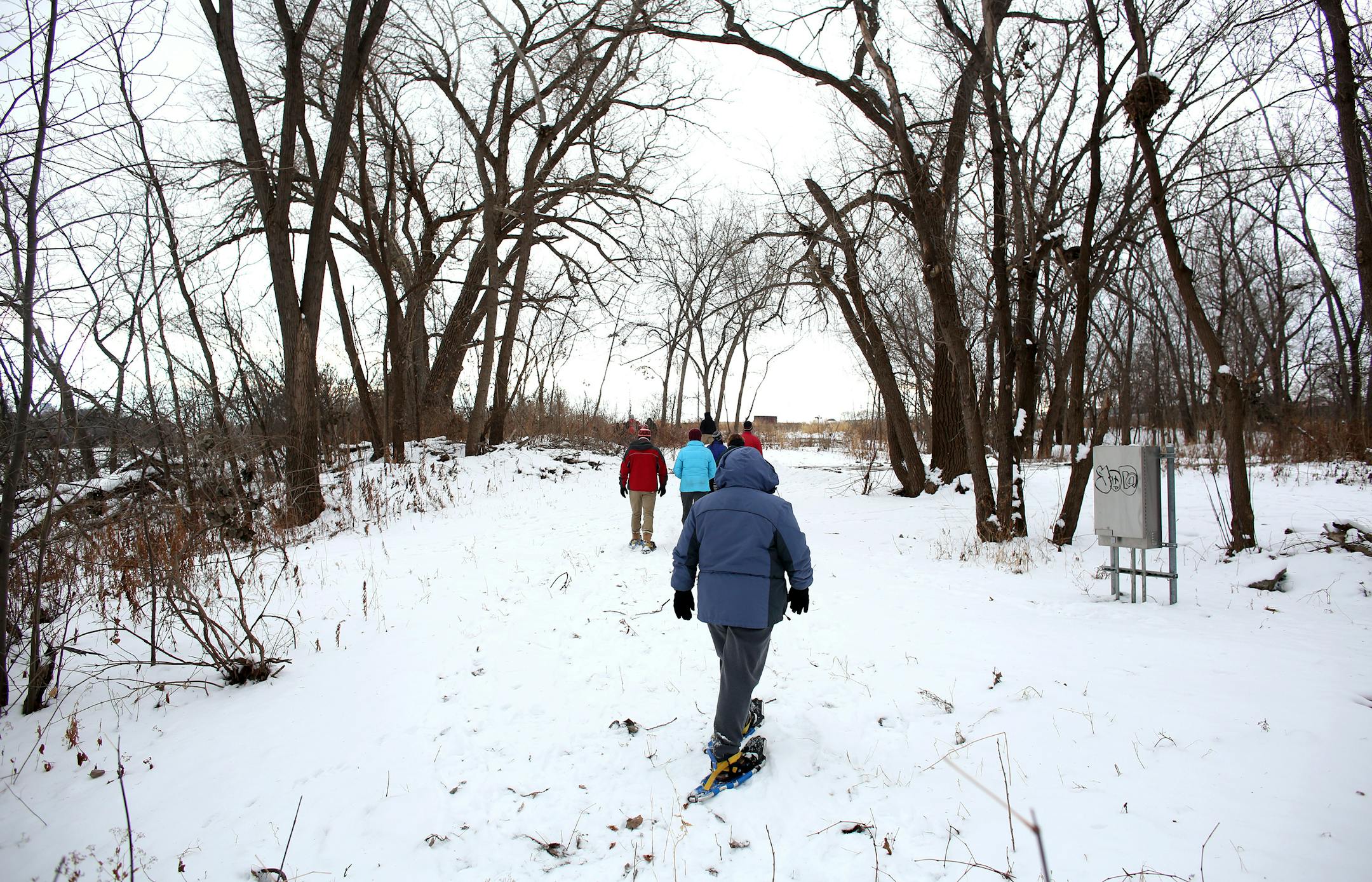 A group of snowshoe hikers headed out along the Mississippi River.