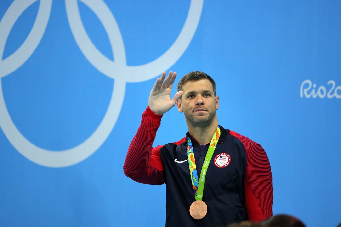 David Plummer waves to his family in the crowd after winning the bronze medal in the 100 backstroke.