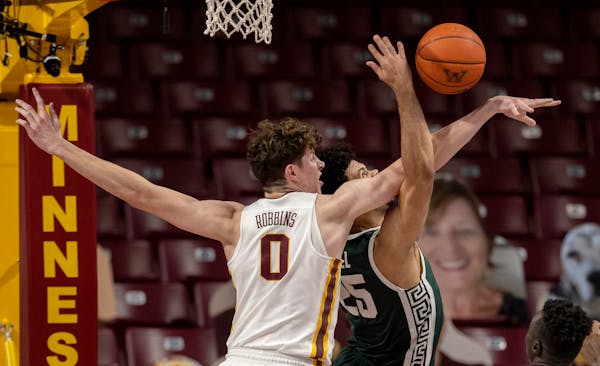 Liam Robbins (0) of Minnesota blocked a shot by Malik Hall (25) of Michigan State in the first half.