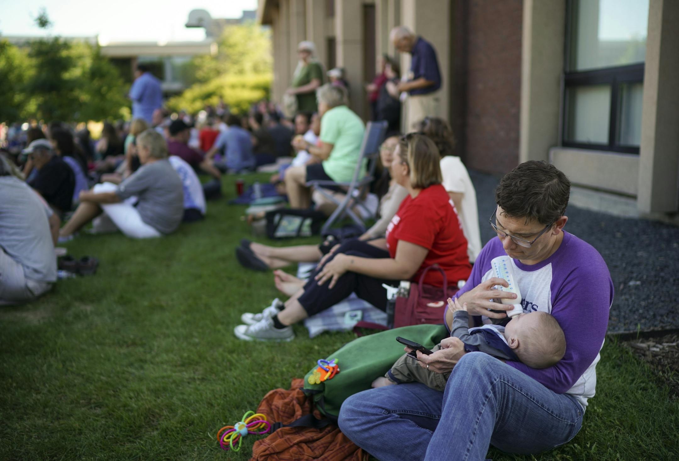 Jonathan Isenor gave his daughter, Ambrose, 7 months, a bottle while waiting for the Town Hall to start.