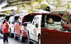 In this March 13, 2015 photo, workers inspect new 2015 aluminum-alloy body Ford F-150 trucks at the company's Kansas City Assembly Plant in Claycomo, 