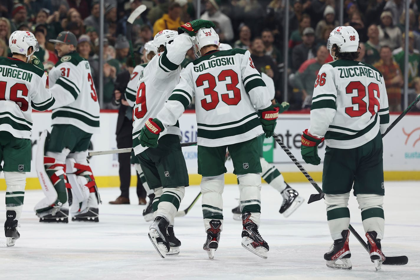 Minnesota Wild defenseman Alex Goligoski (33) celebrates with center Nic Petan (19) after Goligoski scored in overtime against the Carolina Hurricanes during an NHL hockey game Saturday, Nov. 19, 2022, in St. Paul, Minn. (AP Photo/Stacy Bengs)