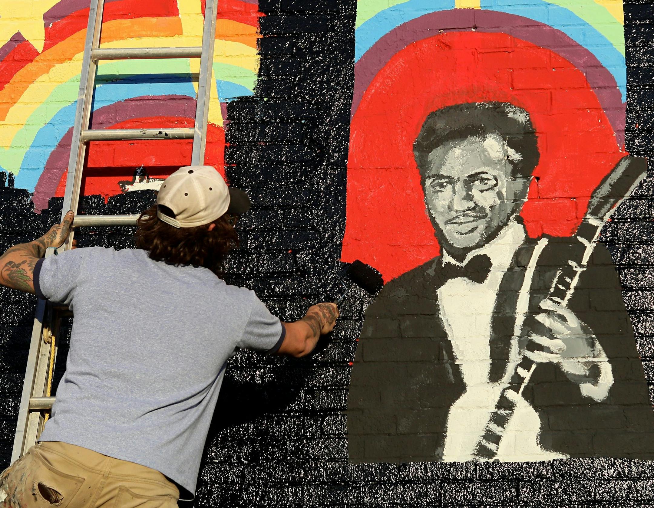 Joe Albanese replaces an old mural with a new painting that will feature the album cover of a new Chuck Berry album at Delmar Loop in St. Louis on Saturday, March 18, 2017. They were surprised to hear that the music legend died as they were working on the project. Earlier in the day, police announced Berry died at the age of 90. (David Carson/St. Louis Post-Dispatch via AP)