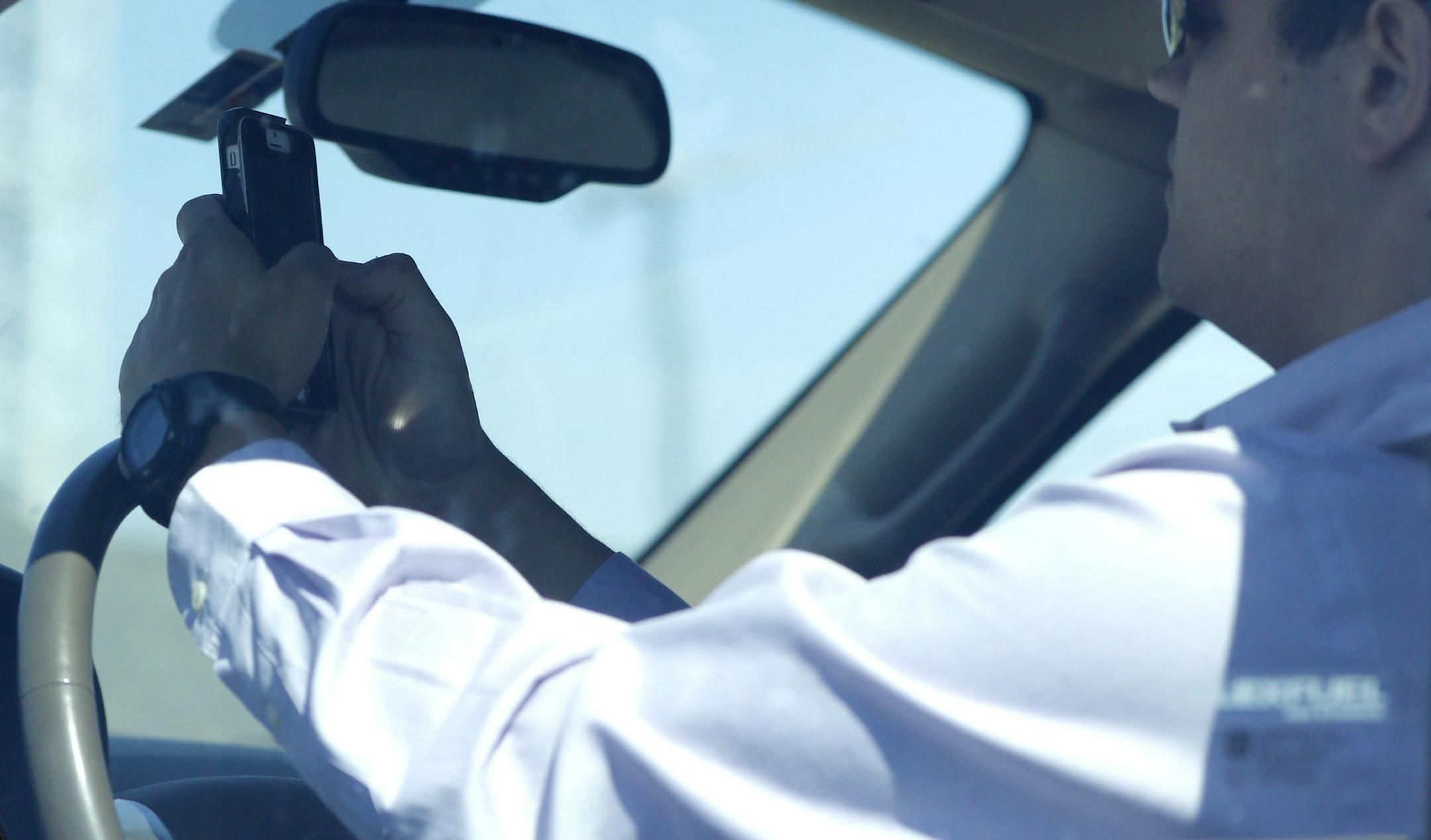 A textident waiting to happen: A man looks at his phone while driving.