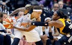 Minnesota Lynx guard Seimone Augustus, left, keeps the ball out of reach of Tulsa Shock guard Karima Christmas, right, during the second half of a WNB