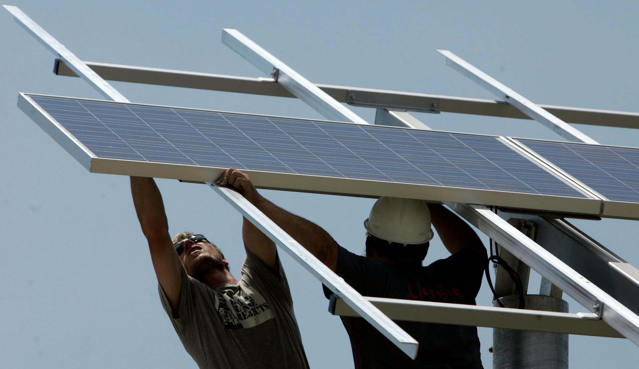 Electrician Jesse Dahl, with the help of his teacher Darryl Thayer, put the second solar panel in place at the Northfield School of Arts &Technology.