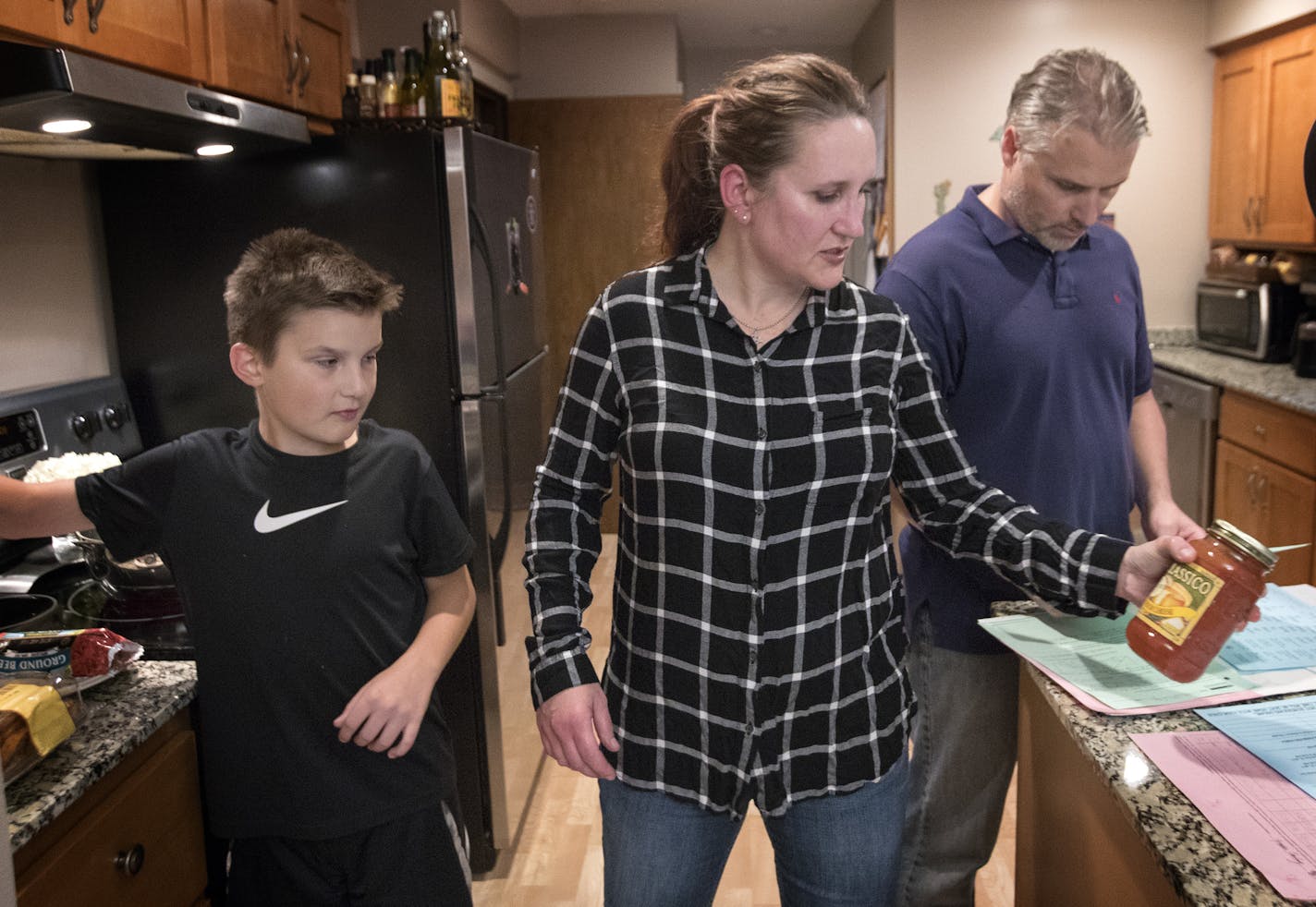 Tina Kill Lenling, son Isaac, 10, and husband Steve Lenling prepared dinner at their St. Paul home. Kill Lenling said the tools she's acquired from the study have helped bring more peace and tranquility to her family life.