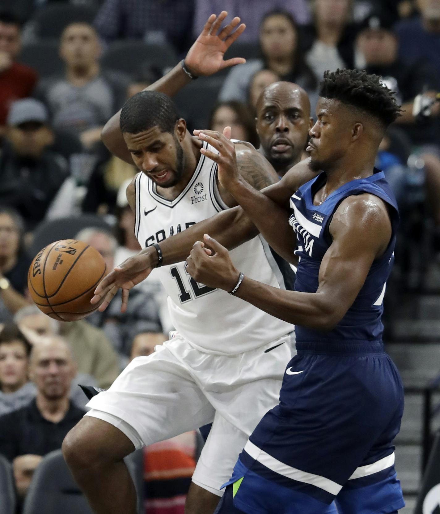 San Antonio Spurs forward LaMarcus Aldridge (12) and Minnesota Timberwolves guard Jimmy Butler, right, scramble for a rebound during the first half of an NBA basketball game, Wednesday, Oct. 17, 2018, in San Antonio. (AP Photo/Eric Gay)