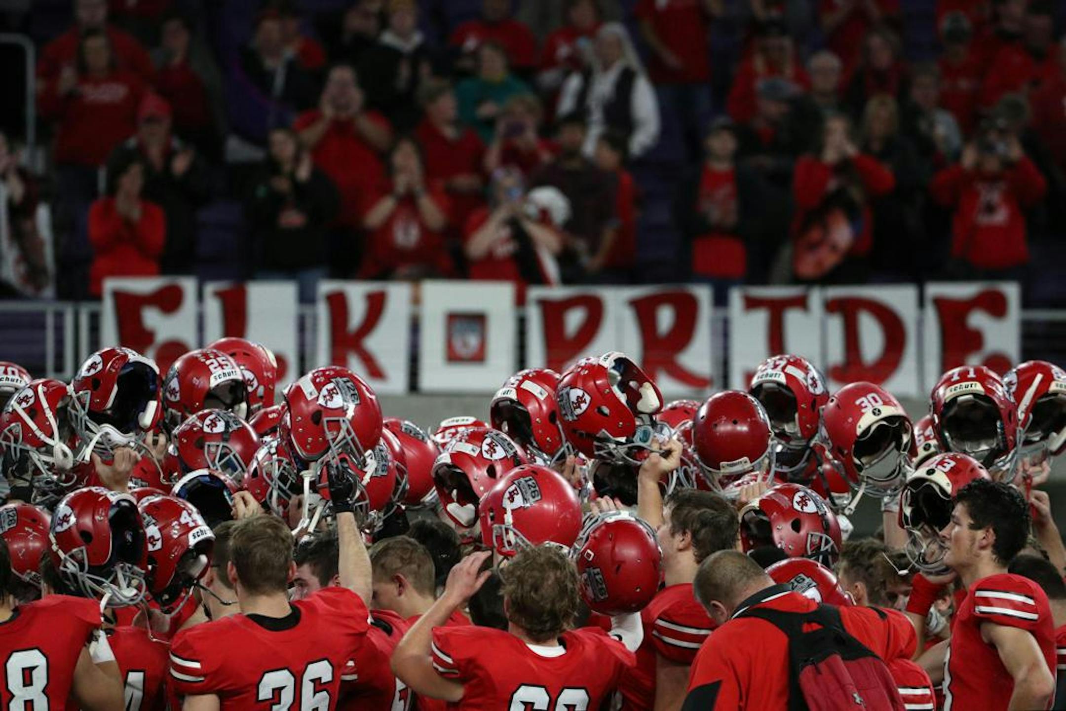 Elk River High School players raised their helmets after a speech by Elk River High School head coach Steve Hamilton following the loss to Owatonna High School. ] ANTHONY SOUFFLE • anthony.souffle@startribune.com