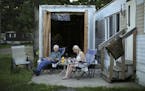 Lisa Bieker ate dinner on her patio with her dad, Joe Bieker. She's lived in a 1962 mobile home at Lowry Grove for five years. She received a diagnosi
