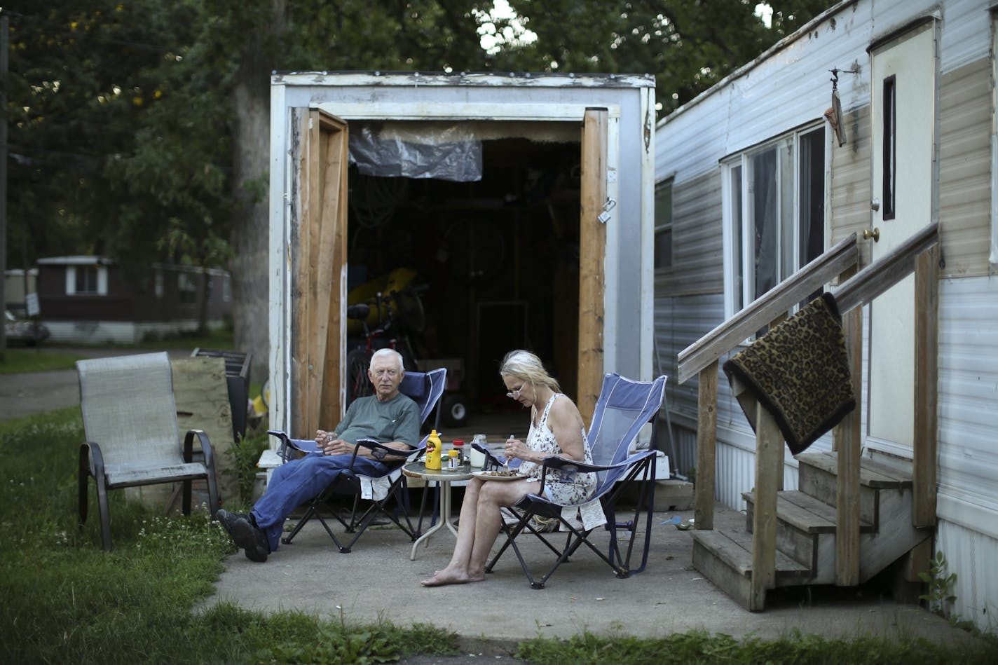 Lisa Bieker ate dinner on her patio with her dad, Joe Bieker. She's lived in a 1962 mobile home at Lowry Grove for five years. She received a diagnosis of terminal cancer earlier this year and doesn't know where she would move if she had to.