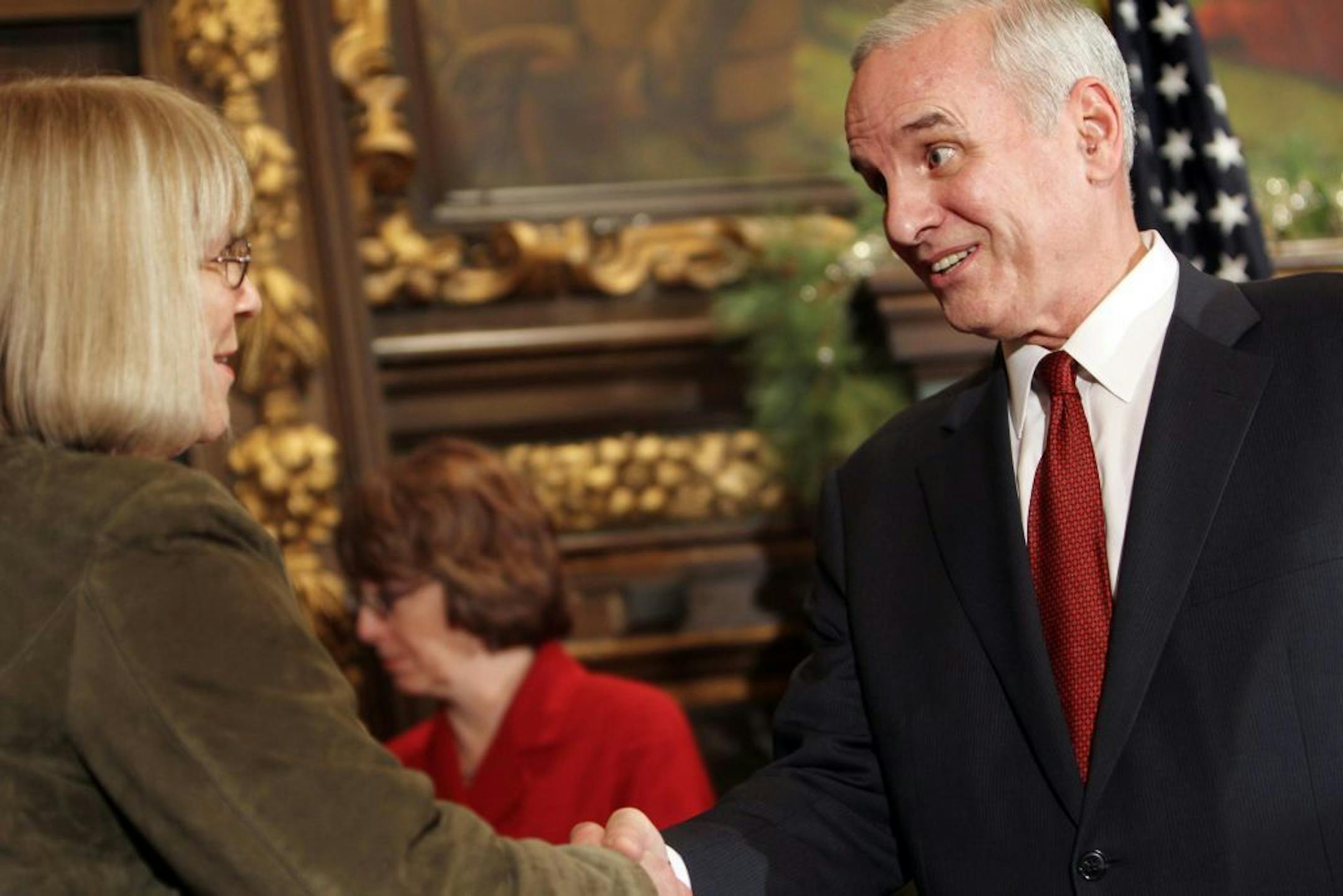 Minnesota Governor Mark Dayton, right, shakes hands with Barb Yates, chair of the Early Learning Council, after a press conference announcing that Minnesota has won a federal Race to the Top Early Learning Challenge grant to advance early education efforts at the State Capitol in St. Paul December 16, 2011.