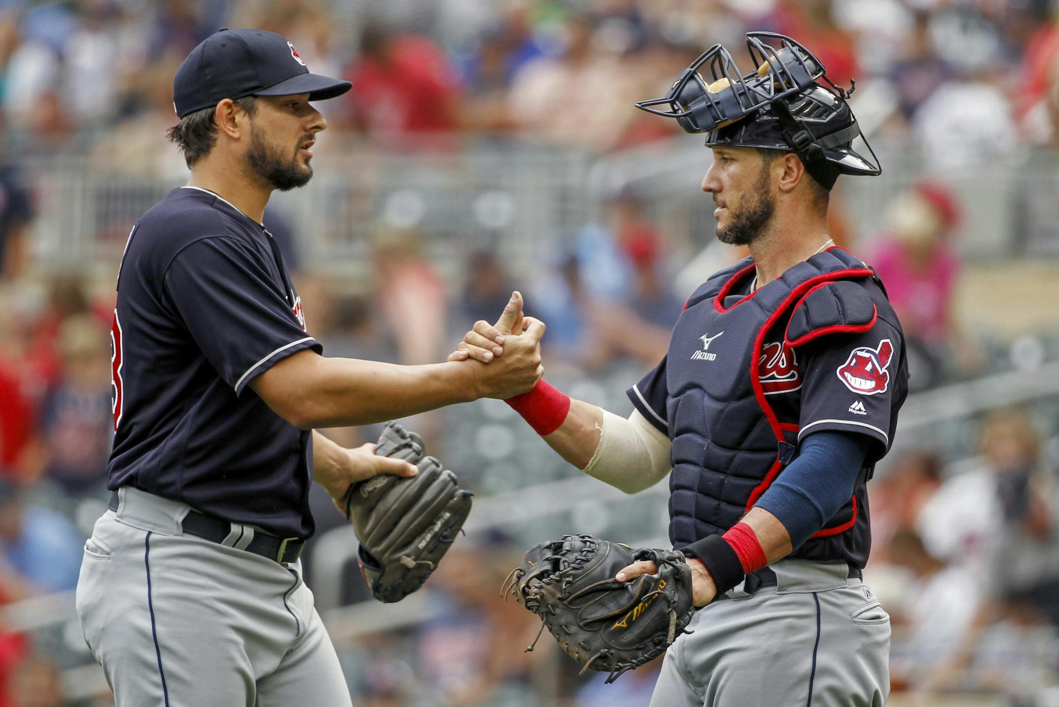 Cleveland Indians relief pitcher Brad Hand, left, celebrates with Yan Gomes after their 2-0 win in a baseball game against the Minnesota Twins, Wednesday, Aug. 1, 2018, in Minneapolis. (AP Photo/Bruce Kluckhohn)