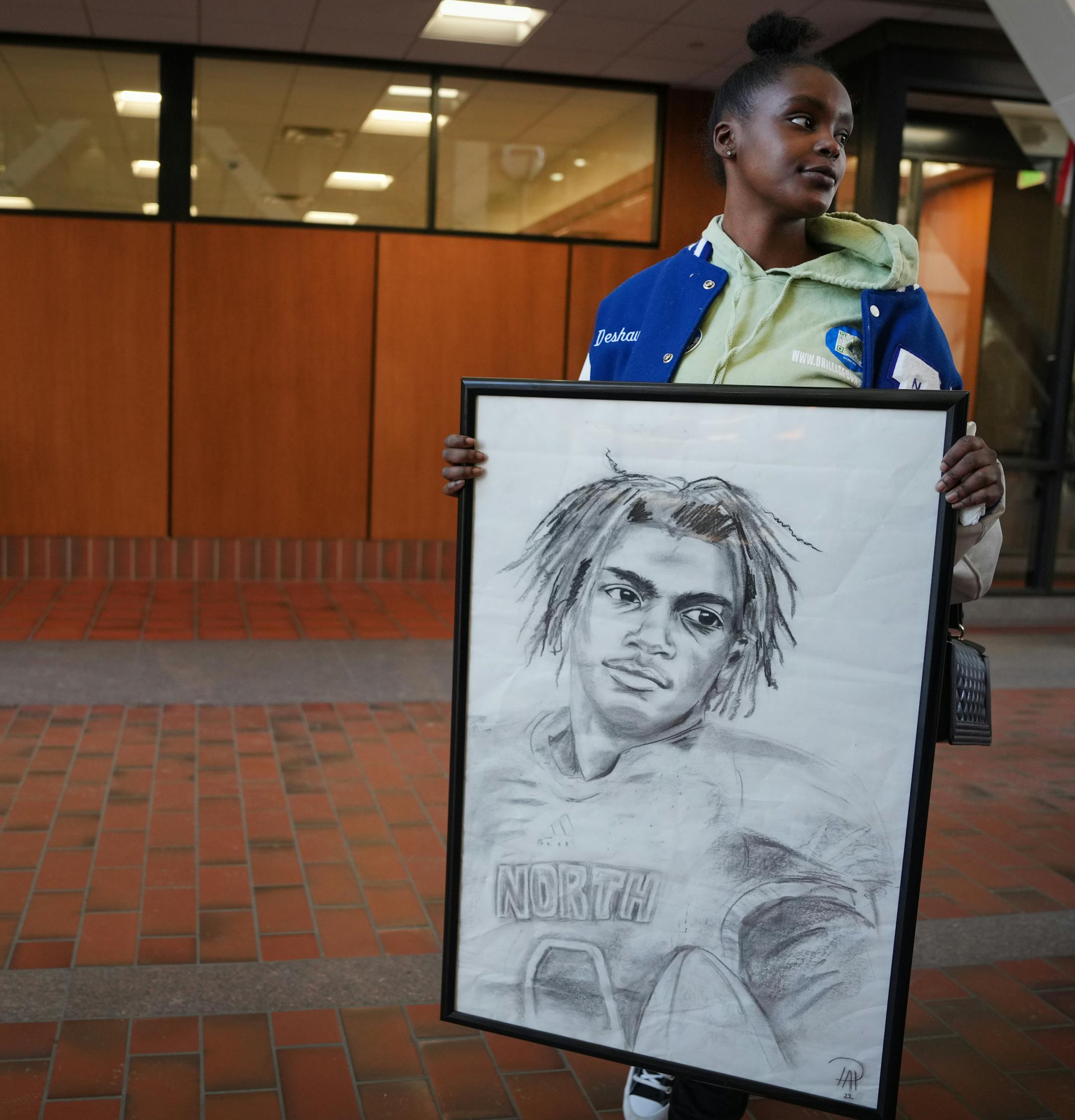 Talina Hill holds artwork depicting her brother, Deshaun Hill, Jr. after the sentencing of Cody Fohrenkam.