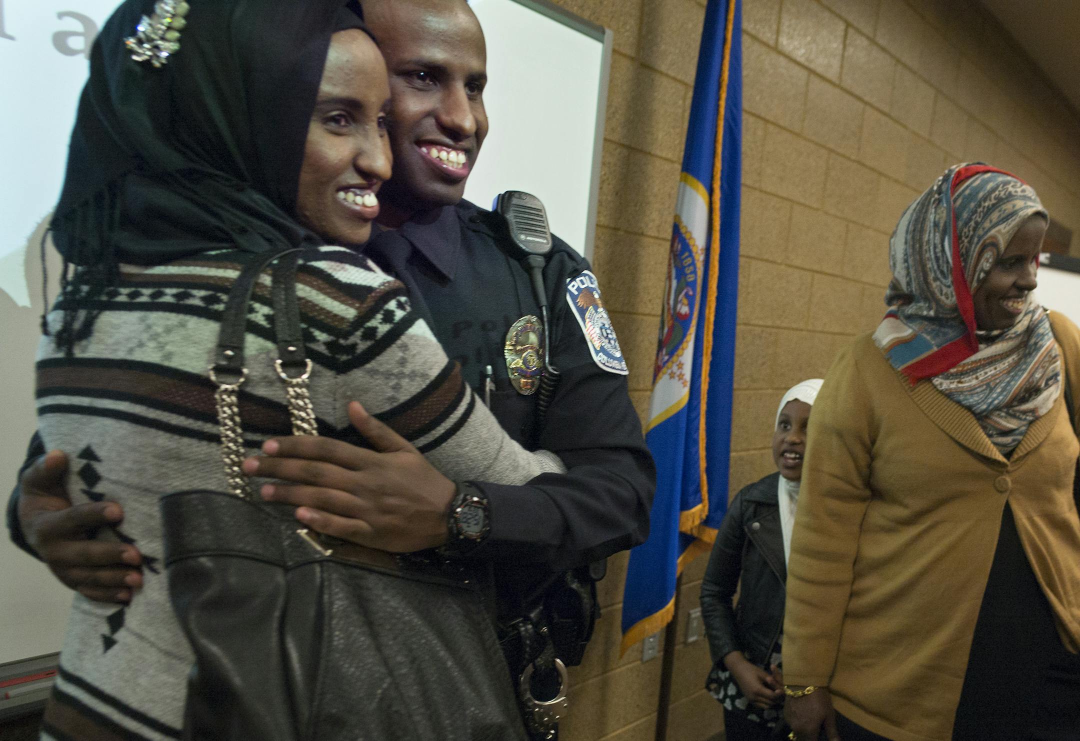 Columbia Heights police's first Somali officer Mohamed Farah was hugged by sister Bisharo as they posed for pictures. His mother is on the right Asha Dolle.] Richard Tsong-Taatatarii@startribune.com