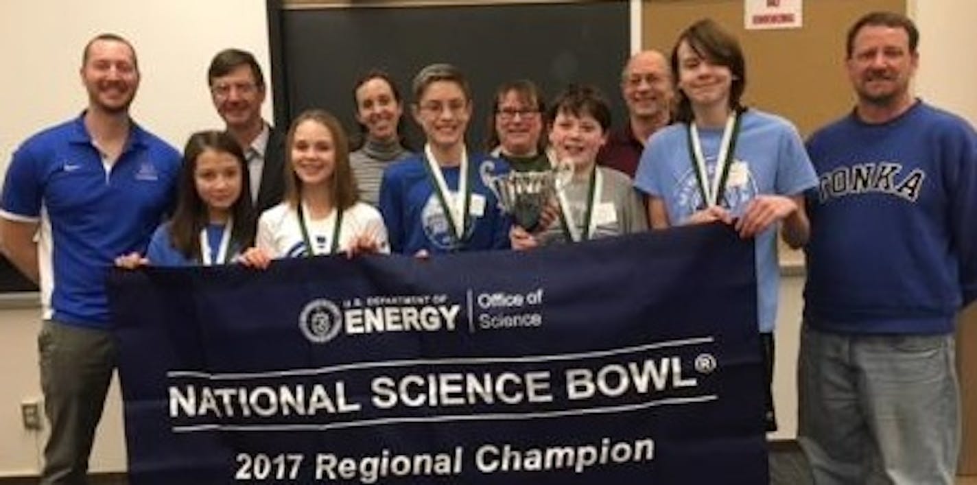 These Minnetonka West Middle School students were proud to hold their championship banner. Left to right, front row: Coach Fred Stock, students Elizabeth Morgan, Emily Nikas, Declan St. John, Rory Cole and Aiden Barker, and Head Coach Mitch Elvebak. The adults in the back row are volunteers who worked in the competition room: Colin Brownlow, Tiffany Senkow Deb Hall and Larry Daniels.