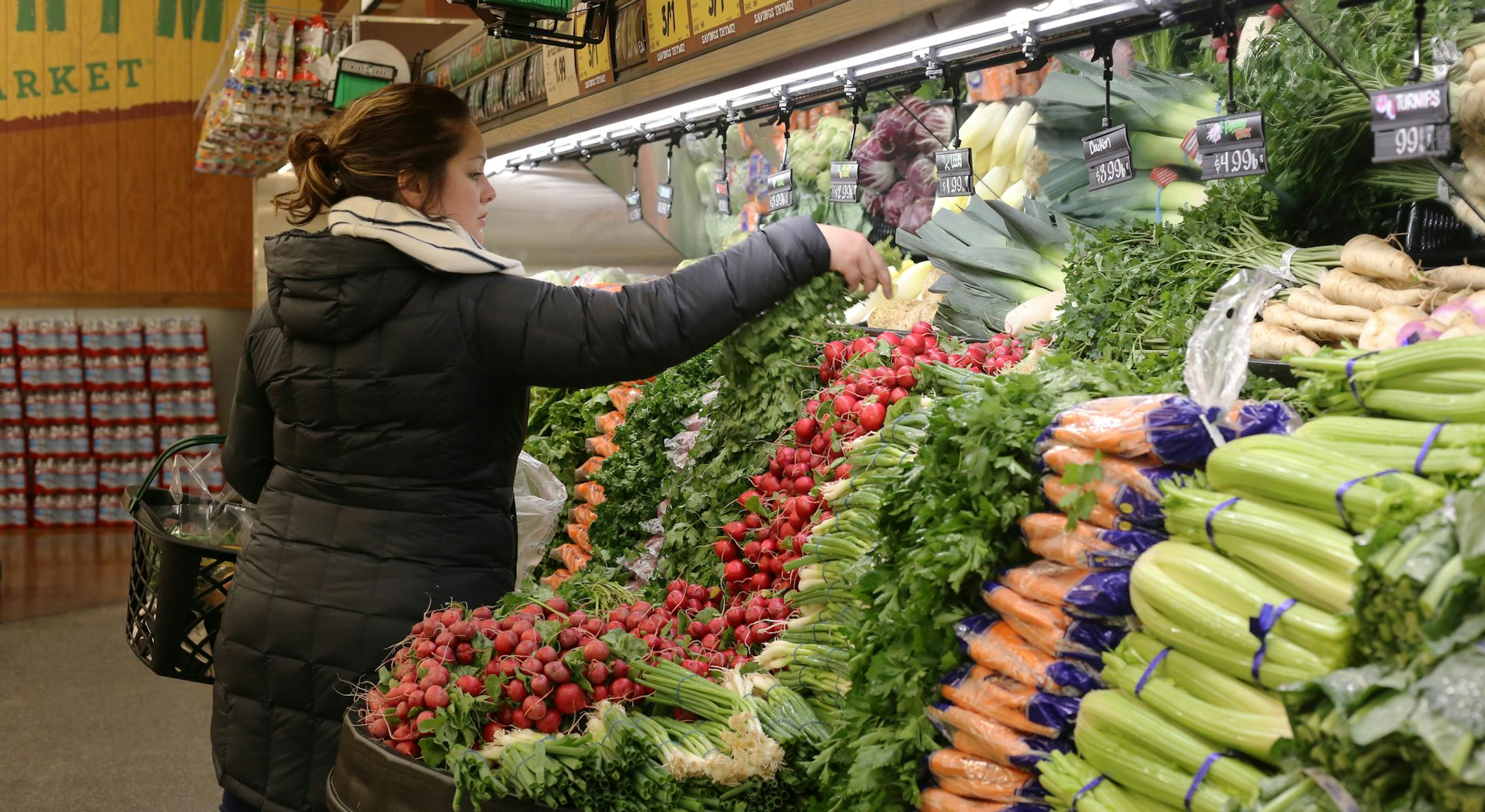 Deb Rasinski chooses vegetables on Tuesday, April 10, 2018 at the Fresh Thyme Market opening in Minneapolis, Minn. Rasinksi said the market is a new convenience since she works across the street. [Ellen Schmidt ï ellen.schmidt@startribune.com
