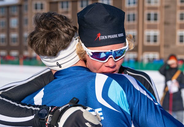 Eden Prairie nordic skier Benon Brattebo (202) embracs Blaine nordic skier Ben Lewis (204) after narrowly beating him to win the boy's freestyle pursu
