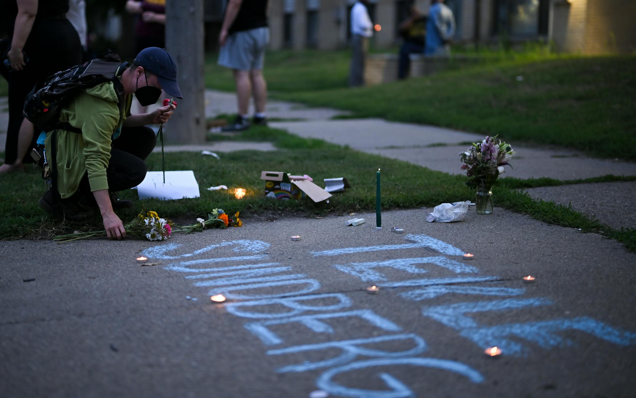 A mourner placed flowers during a vigil Thursday for Andrews Tekle Sunberg.