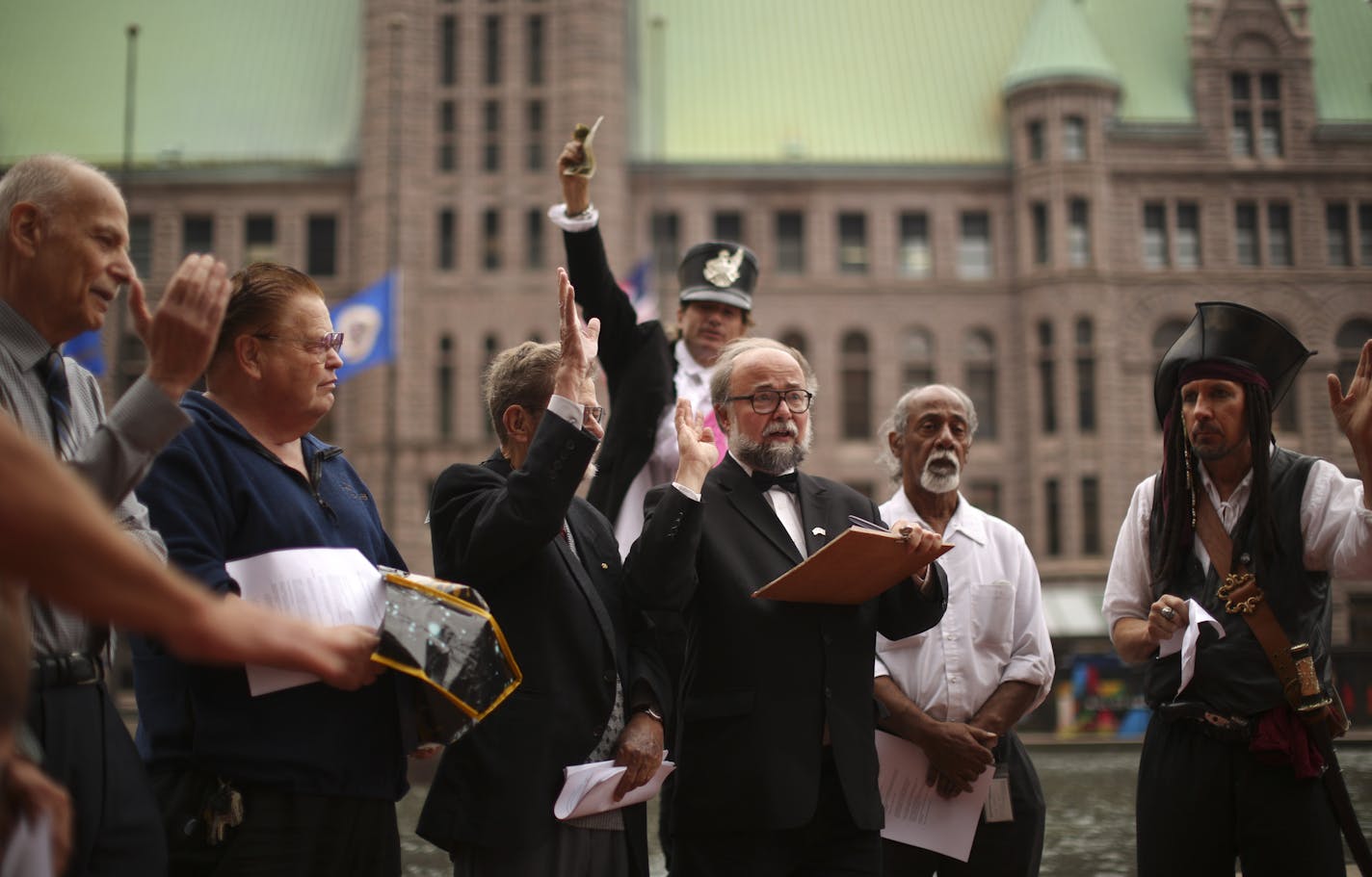 There are so many minor party candidates vying for the job of Minneapolis Mayor that several of them have banded together to form a "Mayoral Council" that meets weekly to advance their causes. The council met for the sixth time Wednesday afternoon, September 18, 2013 at Government Plaza across from City Hall in Minneapolis. The ten candidates who attended the Mayoral Council on Wednesday agreed to agree on several issues. Candidate Bob "Again" Carney Jr., with the clipboard, ran the meeting of t