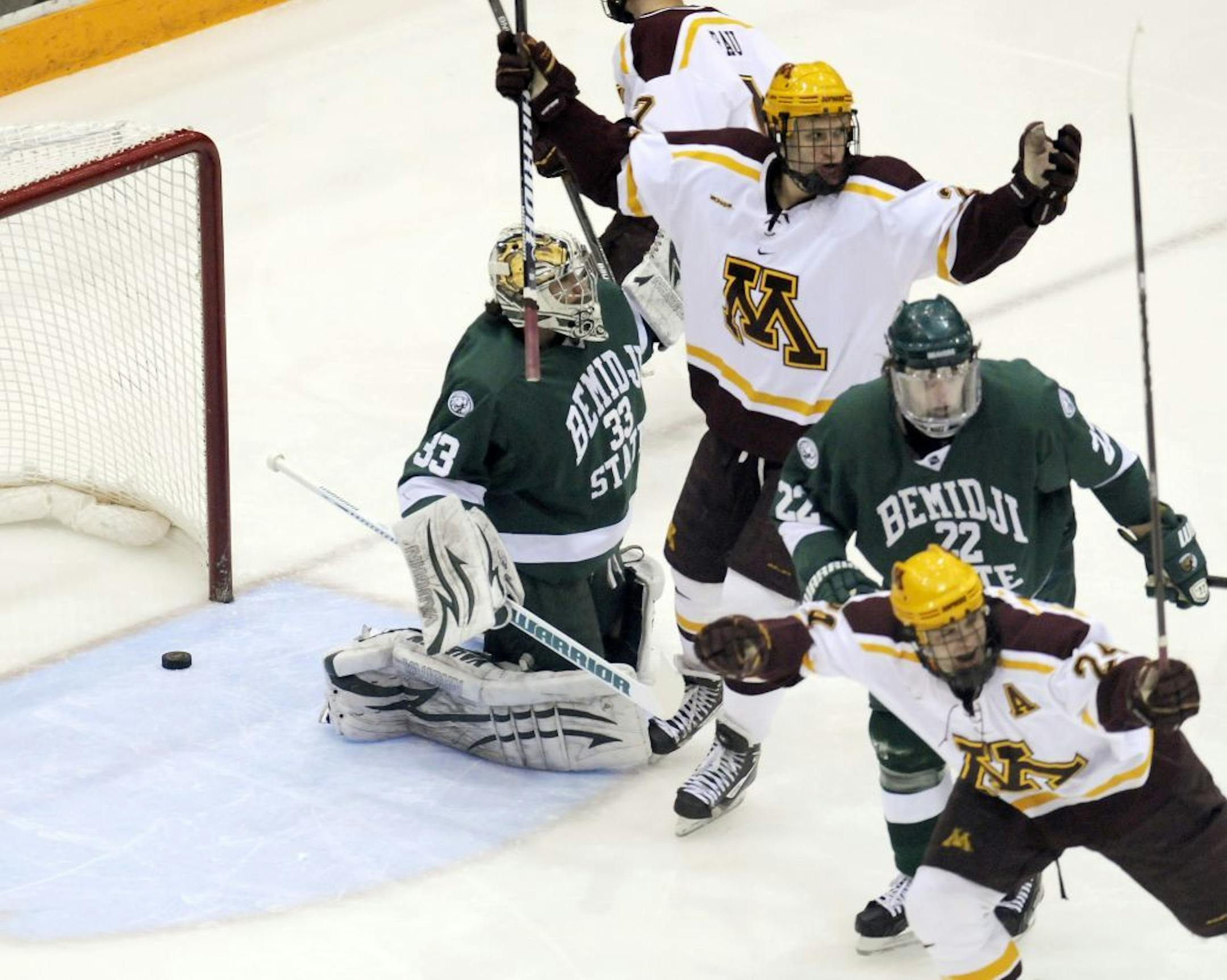 Minnesota's Zach Budish, bottom right, celebrates the first of his two goals past Bemidji State goalie Dan Bakala and Matt Prapavessis with teammate Nick Bjugstad in the first period of a college hockey game in Minneapolis, Friday, Feb. 17, 2012. Minnesota won 3-0.