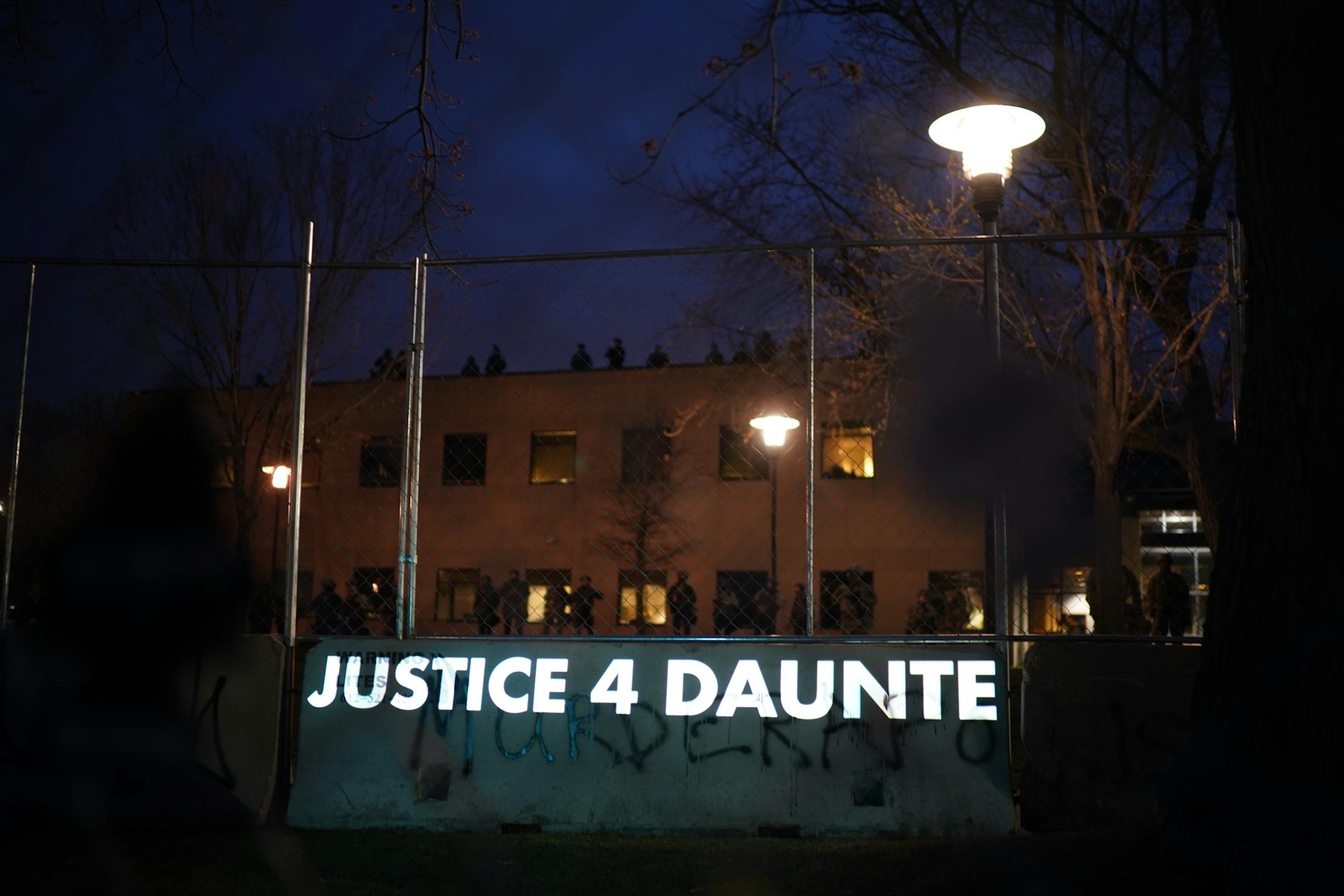 Messages were projected onto the barrier separating  demonstrators from police. Demonstrators gathered for a protest near the Brooklyn Center Police Department on Thursday, April 15, 2021 in response to the fatal police shooting of Daunte Wright in Brooklyn Center, Minn.