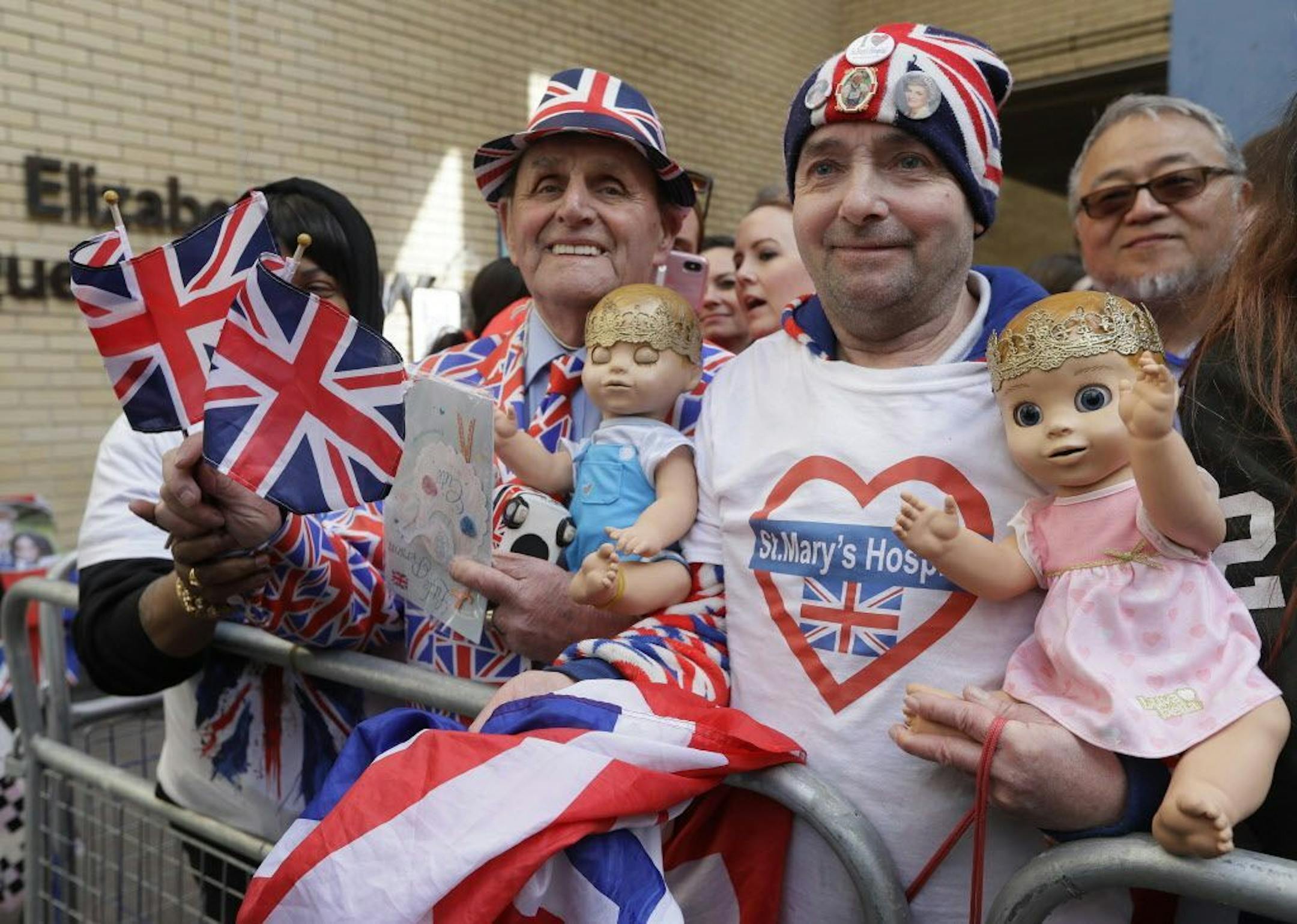 Royal fans John Loughrey, right, and Terry Hutt pose for a photo opposite the Lindo wing at St Mary's Hospital in London London, Monday, April 23, 2018. Kensington Palace says Prince William's wife, the Duchess of Cambridge has entered a London hospital to give birth to the couple's third child.