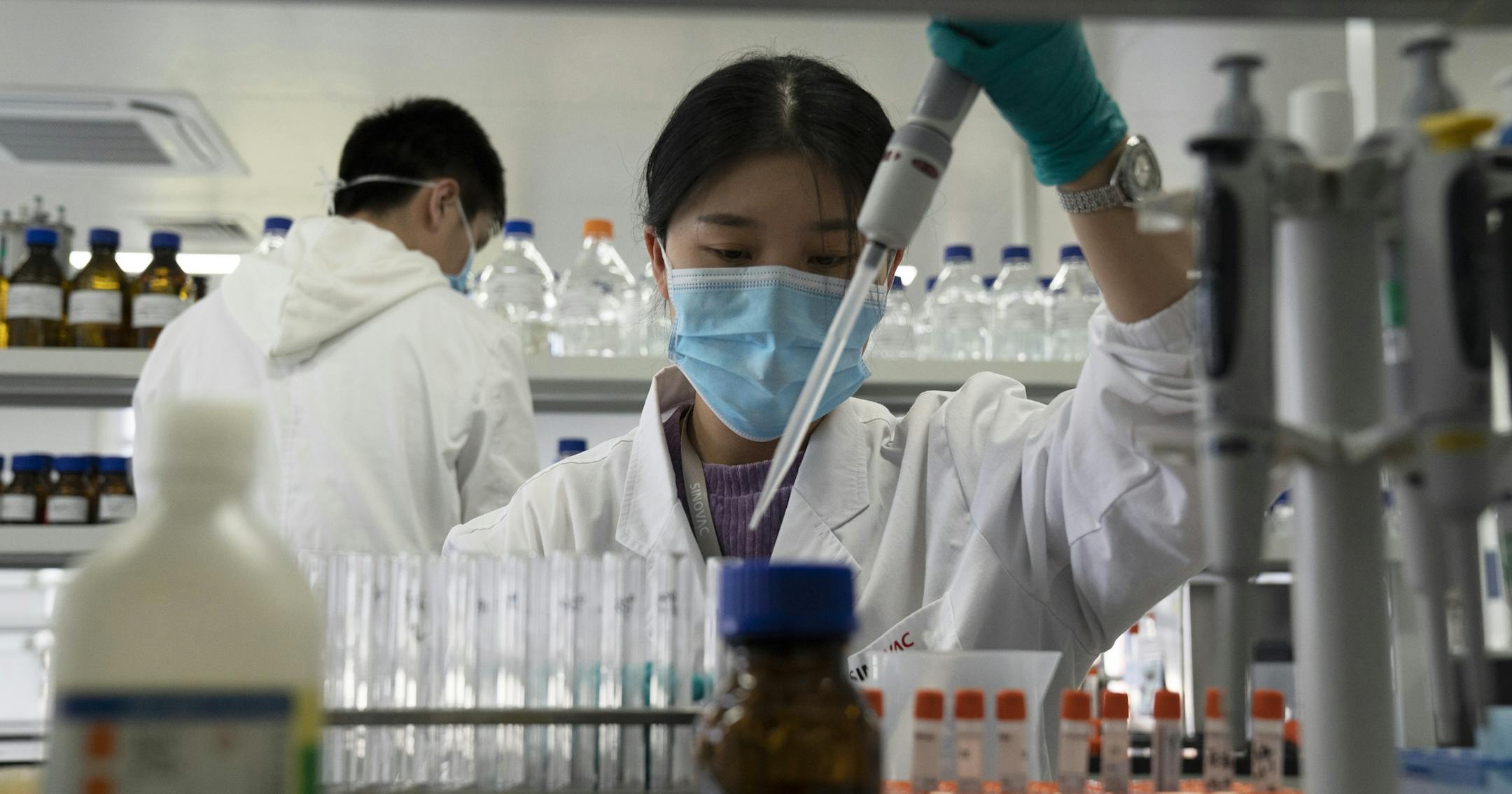 FILE - In this Sept. 24, 2020, file photo, an employee of Sinovac works in a lab at a factory producing its SARS-CoV-2 vaccine for COVID-19 named CoronaVac in Beijing. China is rapidly increasing the number of people receiving its experimental coronavirus vaccines, with a city offering one to the general public and a biotech company providing another free to students going abroad. (AP Photo/Ng Han Guan, File)