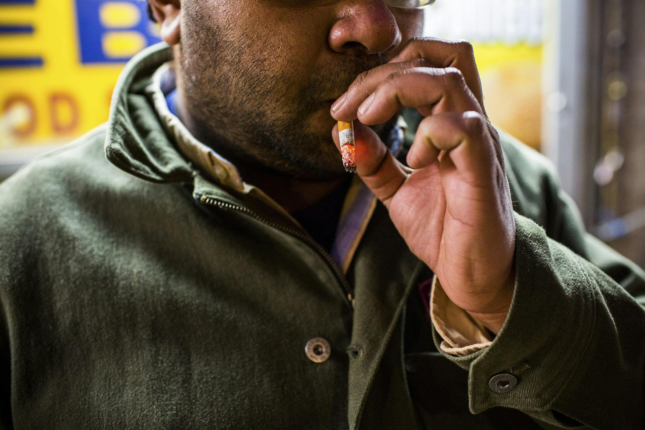 FILE — A smoker on Flushing Avenue in New York, Jan. 19, 2017. New York Mayor Bill de Blasio is supporting a series of initiatives to cut tobacco use, including reducing the number of stores allowed to sell tobacco products and raising the minimum price of a pack of cigarettes to $13. (Stephen Speranza/The New York Times)