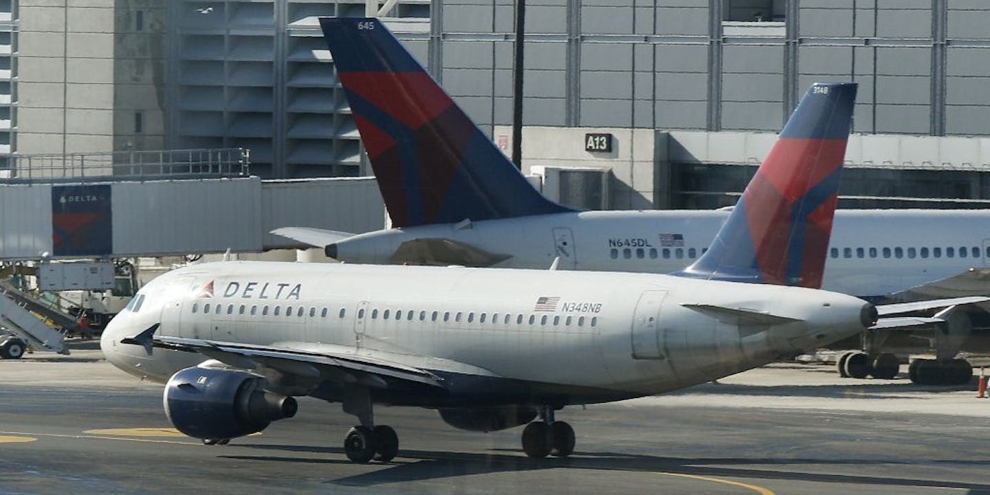 A Delta Airlines plane taxis past a gate at Logan Airport in Boston Tuesday, Jan. 24, 2012. Delta Air Lines said Wednesday, Jan. 25, 2012, it earned $425 million in the fourth-quarter as it raised prices in the critical holiday season and the airline reduced flying to keep costs low.