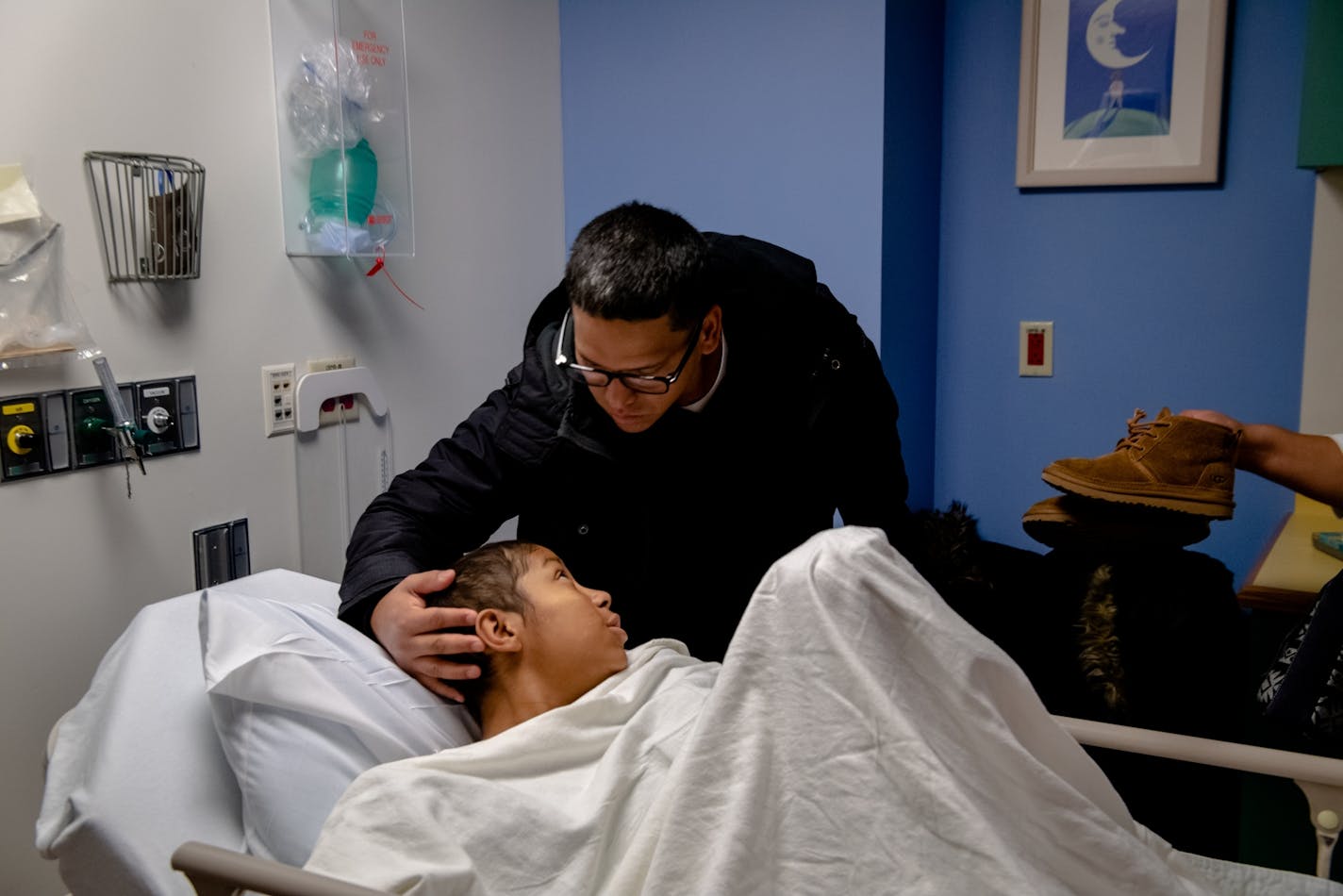 Byron Obando comforts his daughter Helen, the youngest person ever to receive a gene therapy for sickle cell anemia, before a surgery in Boston. UnitedHealth Group is backing a study that hopes to determine whether carrying the genetic trait that causes sickle cell disease could put a subset of Black Americans at greater risk from COVID-19.