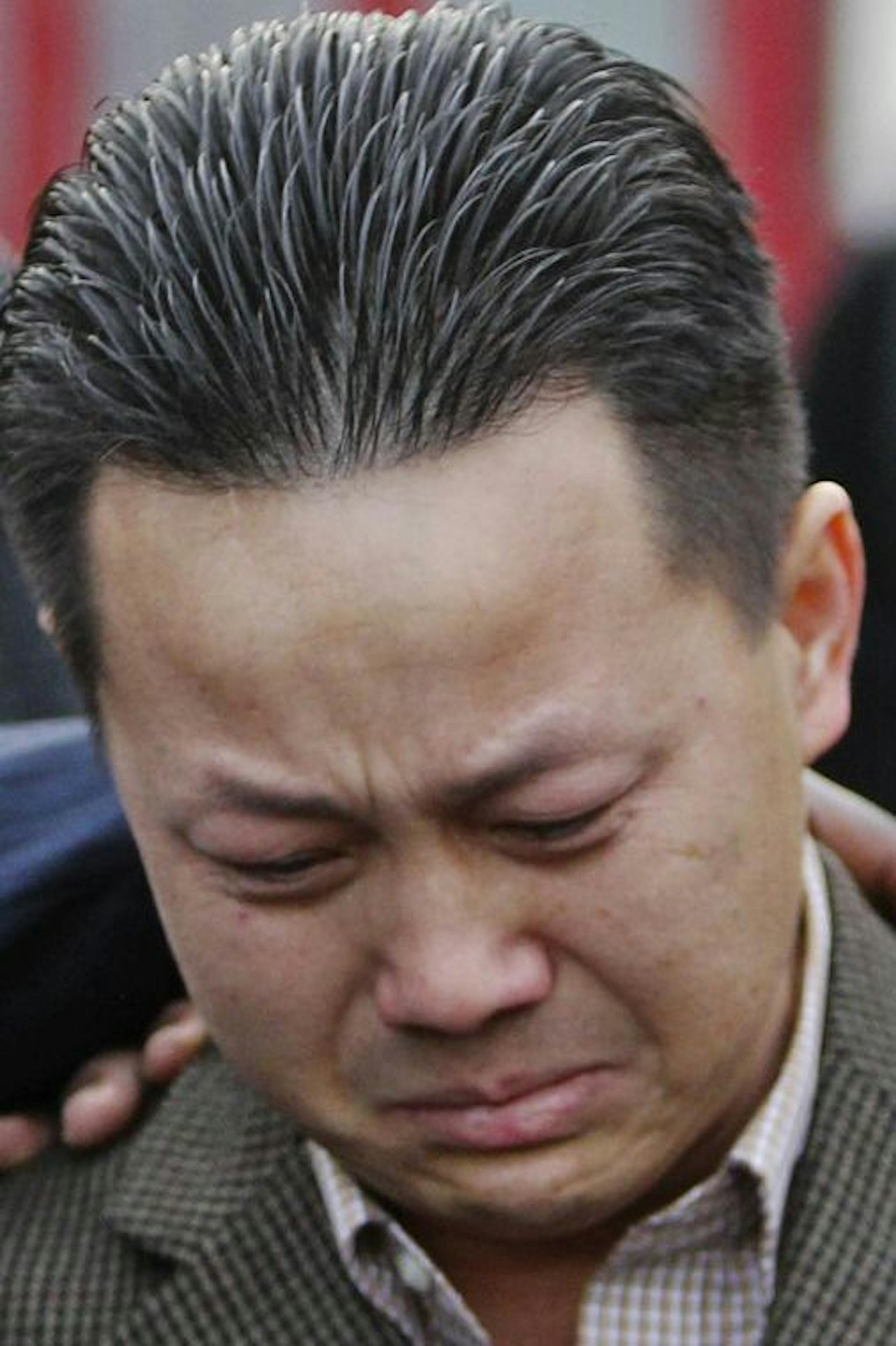 Kia Xiong, the father of two-year old shooting victim Neegnco Xiong, is comforted by Rev. Harding Smith of the Spiritual Church of God, left, and peace activist K.G. Wilson, right, as Xiong fought back tears while remembering his son during a vigil near the family's Cedar-Riverside area residence Saturday, Dec. 8, 2012, in Minneapolis, MN.] (DAVID JOLES/STARTRIBUNE) djoles@startribune.com) A vigil was held for two-year old shooting victim Neegnco Xiong near the family's Cedar-Riverside area resi