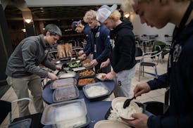Head coach Sean Bloomfield helps set some lunch for his team on Thursday.
