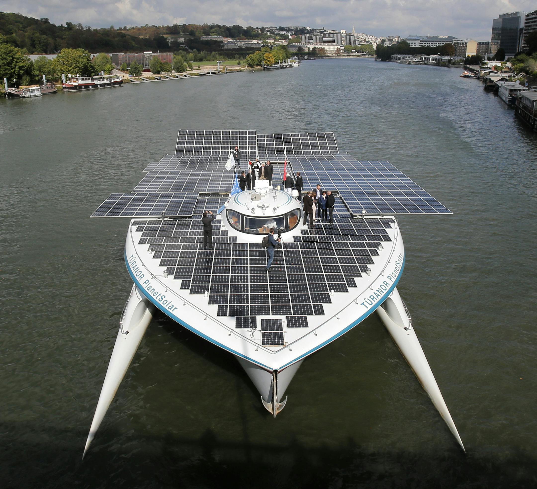 The Turanor PlanetSolar, the world's largest solar boat, travels on the Seine river in Sevres, outside Paris, Tuesday, Sept. 10, 2013. The PlanetSolar with its 537 square meters of photovoltaic panels powering 6 blocks of lithium-ion batteries, accomplished the first around the world trip powered only by solar energy in May 2012. (AP Photo/Christophe Ena)