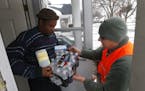 Louis Singleton receives water filters, bottled water and a test kit from Michigan National Guard Specialist Joe Weaver as clean water supplies are di