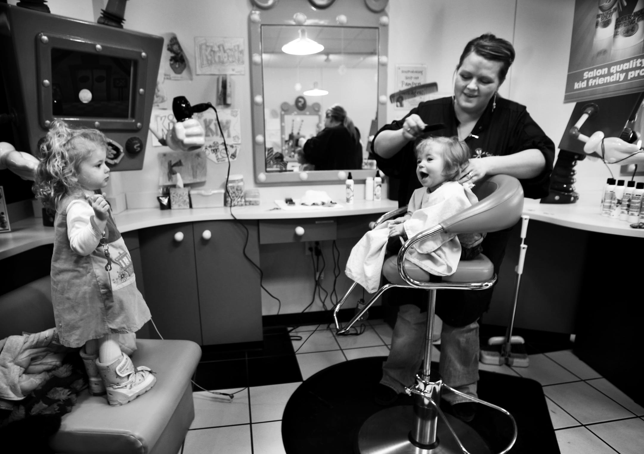 DAVID JOLES * djoles@startribune.com St. Paul, MN - Jan. 30, 2010 - �Maggie Lund, 8 months, got her first haircut recently at Snip-its in Maple Grove under the watchful eye of her mom, Sarah, dad Erik, and big sister Lucy, 2 1/2, who are from Long Lake. The day was full of anticipation. "She was born with a whole head of hair. We were a little nervous that she'd scream and cry," said mom, Sarah. In the end, Maggie did fine, smiling much of the time and leaving her mom feeling a bit nostalgic. "I