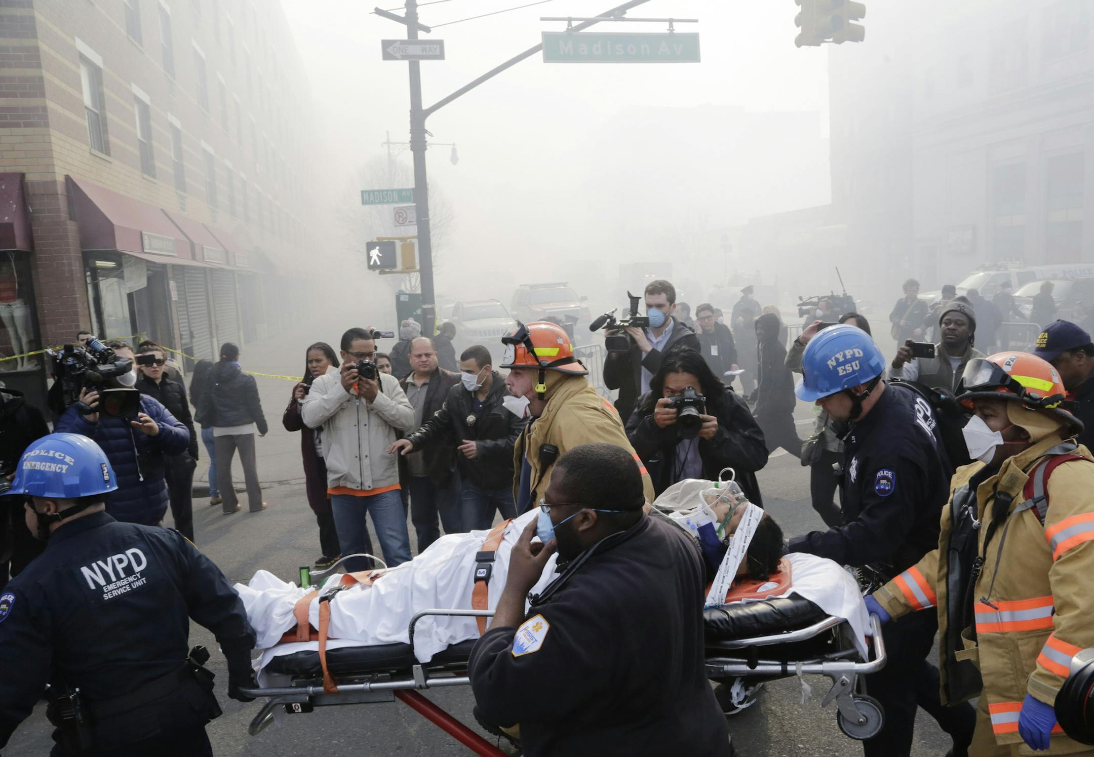 Rescue workers remove an injured person on a stretcher after a possible explosion and building collapse in the East Harlem neighborhood of New York, Wednesday, March 12, 2014