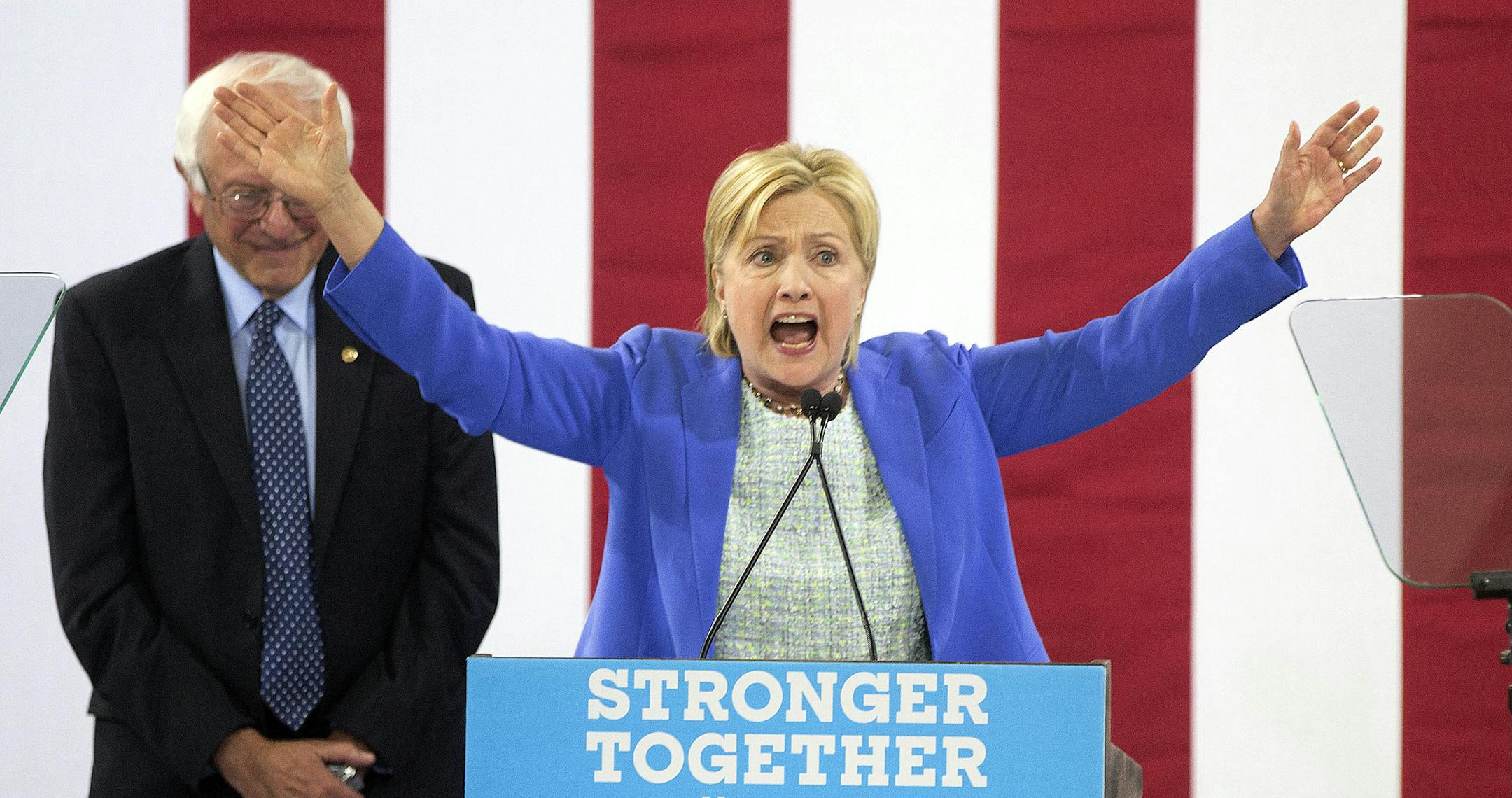 Sen. Bernie Sanders, I-Vt., listens as Democratic presidential candidate Hillary Clinton speaks during a rally in Portsmouth, N.H., Tuesday, July 12, 2016, where Sanders endorsed Clinton for president. (AP Photo/Jim Cole)