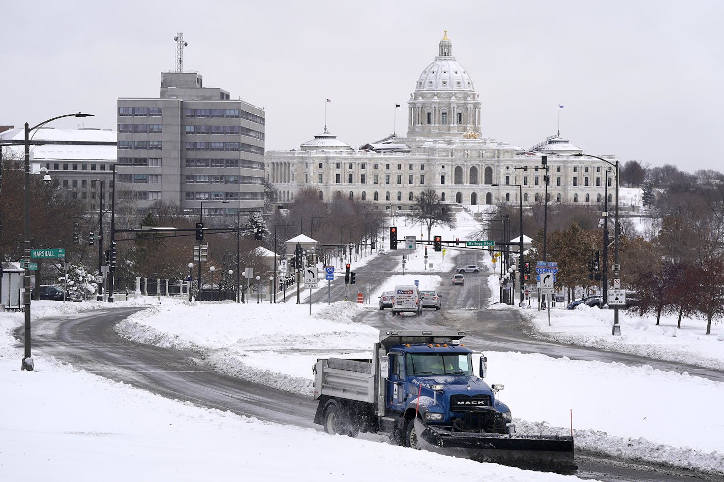 A plow truck made its way up the hill in front of the Cathedral of St. Paul on Wednesday, with the State Capitol building in the backdrop. More snow is coming this weekend.