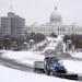 A plow truck made its way up the hill in front of the Cathedral of St. Paul on Wednesday, with the State Capitol building in the backdrop. More snow i