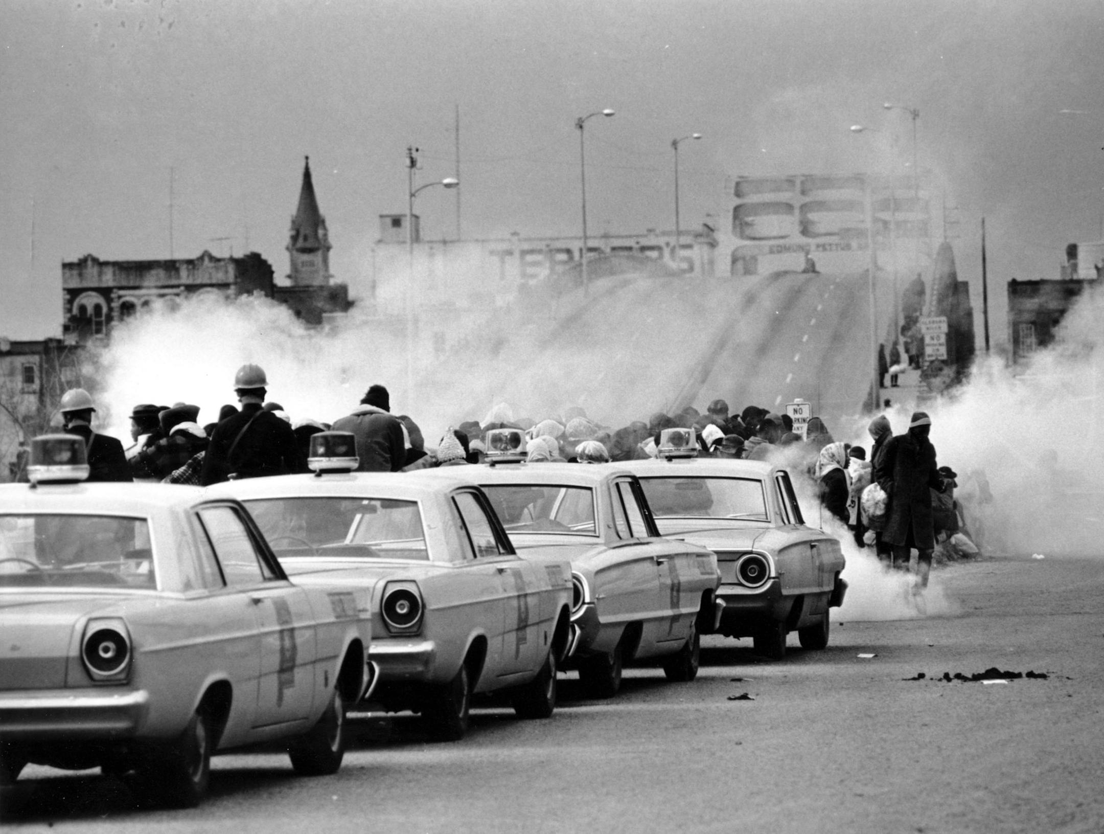 FILE - In this March 7, 1965, file photo tear gas fills the air as state troopers, ordered by Alabama Gov. George Wallace, break up a march at the Edmund Pettus Bridge in Selma, Ala., on what became known as Bloody Sunday. President Barack Obama is marking the 45th anniversary of "Bloody Sunday" by praising "these heroes" who marched into history and endured beatings by Alabama state troopers at the start of their landmark voting rights trek. The nation's first black president says that despite
