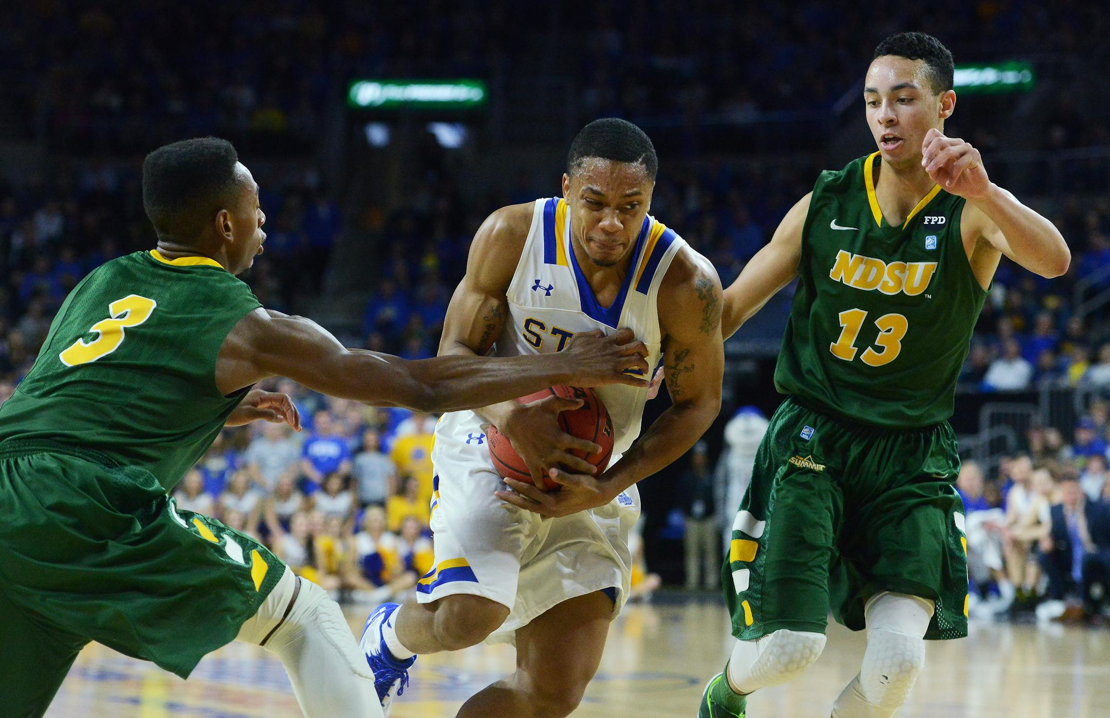 South Dakota State's George Marshall (11) tries get past North Dakota State's Carlin Dupree (3) and Khy Kabellis (13) during the Summit League men's tournament championship, Tuesday, March 8, 2016, in Sioux Falls, S.D.