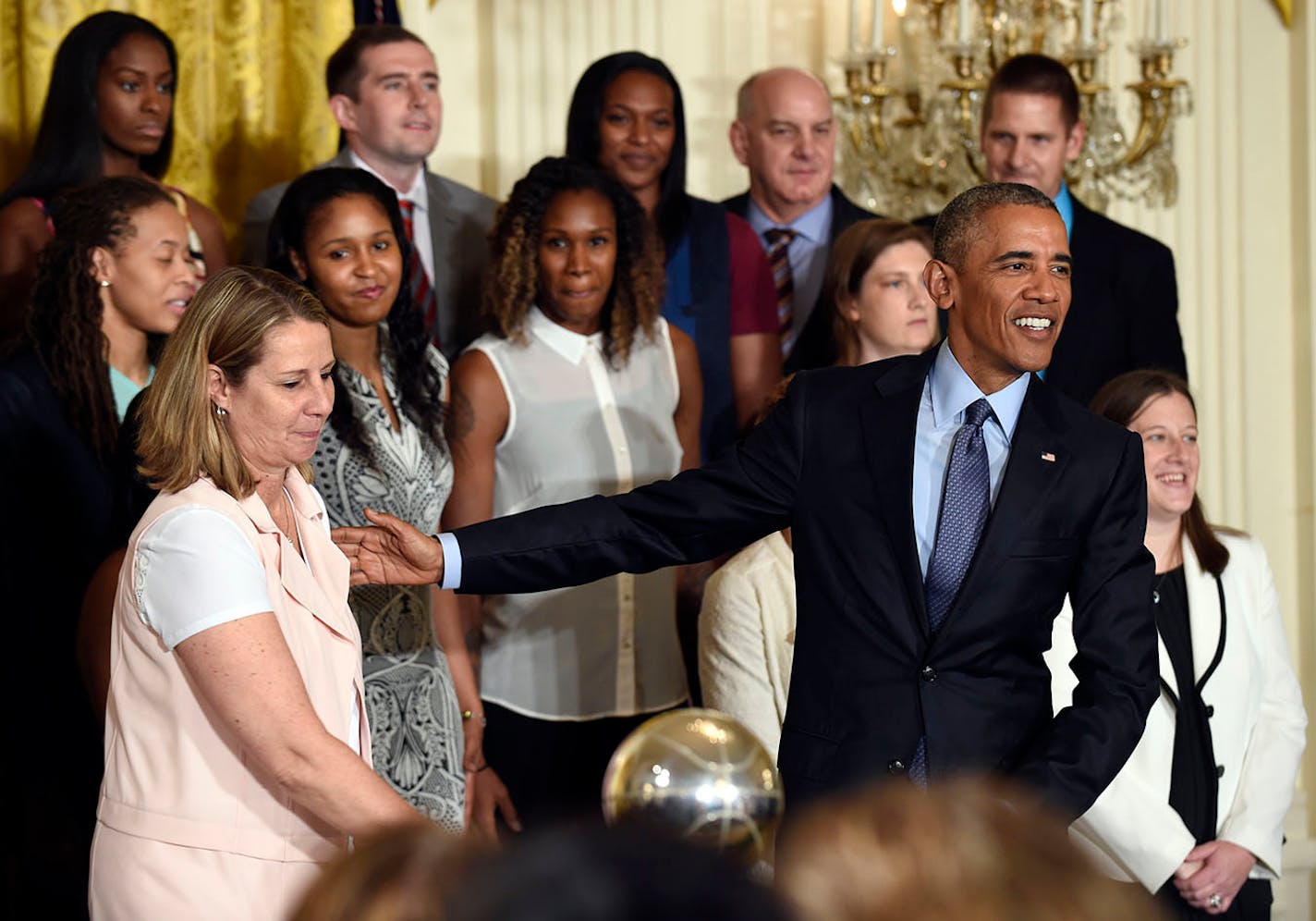 President Barack Obama, front right, reaches out to Minnesota Lynx coach Cheryl Reeve in the East Room of the White House in Washington, Monday, June 27, 2016, during a ceremony where Obama honored the 2015 WNBA basketball Champion Minnesota Lynx.