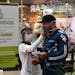 In this June 9, 2020 photo, a nurse measures the body temperature of a shopper at the El Tesoro mall, amid the new coronavirus pandemic, in Medellin, 